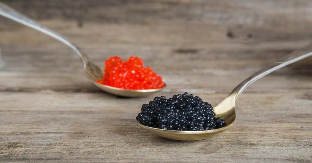 Two Types of Caviar in Two Different Spoons Placen on the Wooden Table